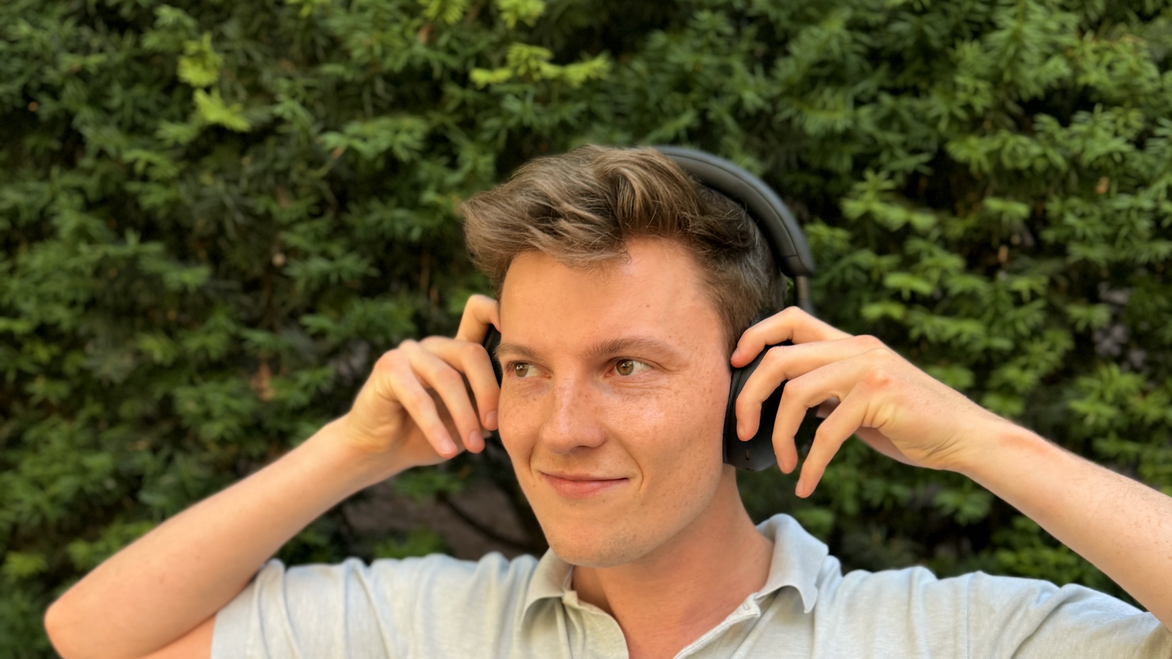 A man listening to a meditation through headphones outdoors